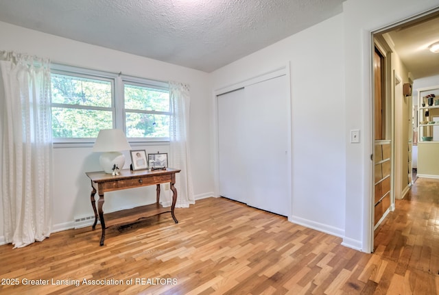 4451 Greenwood Dr, Okemos, MI 48864 - bedroom with light wood finished floors, a textured ceiling, an office area, and a closet