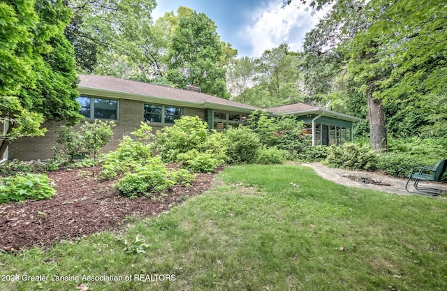 4451 Greenwood Dr, Okemos, MI 48864 - view of front of home featuring a chimney, a front lawn, and brick siding