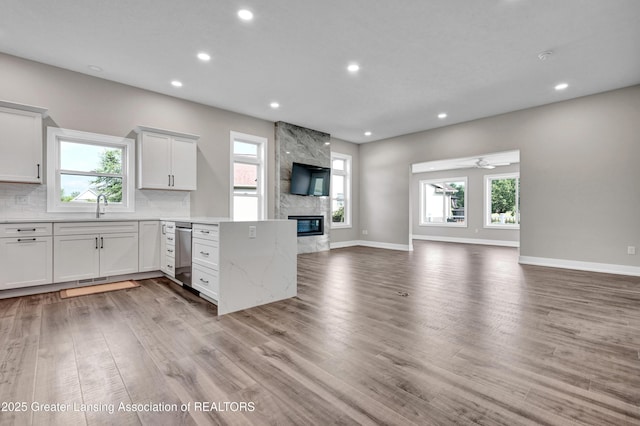 330 Vansickle Dr Unit 31, Charlotte, MI 48813 - kitchen featuring open floor plan, a peninsula, recessed lighting, light wood-style floors, and tasteful backsplash
