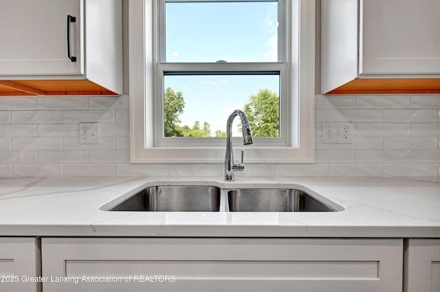330 Vansickle Dr Unit 31, Charlotte, MI 48813 - kitchen featuring decorative backsplash, white cabinets, and light stone countertops