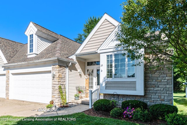 26 Aviemore Dr, Mason, MI 48854 - view of front facade with a garage, stone siding, roof with shingles, and driveway