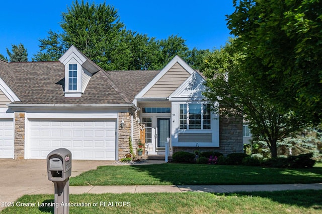 26 Aviemore Dr, Mason, MI 48854 - view of front of home featuring stone siding, an attached garage, concrete driveway, a front yard, and a shingled roof