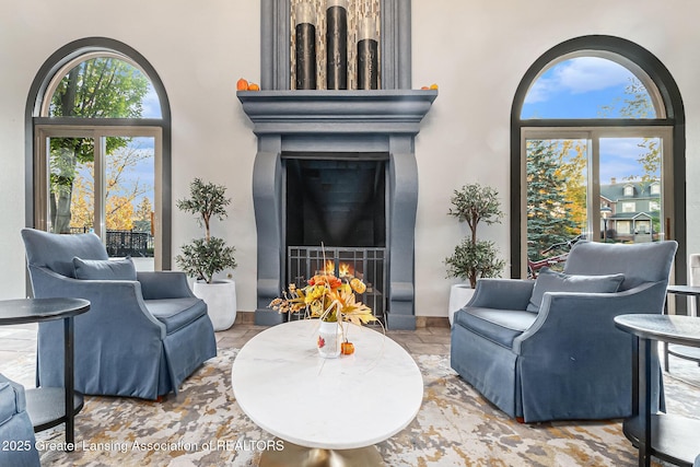 3706 Flying Gulch Dr, Holt, MI 48842 - living area featuring a warm lit fireplace and stone finish flooring