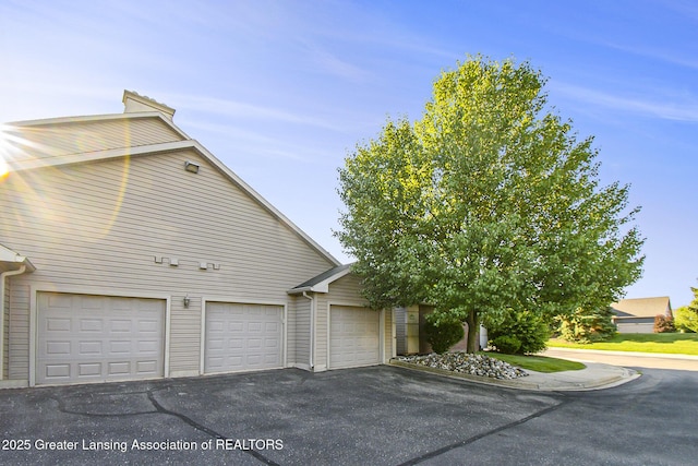 3706 Flying Gulch Dr, Holt, MI 48842 - view of side of home featuring driveway and a garage