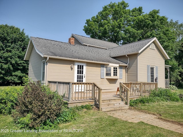 16711 Stark Rd, Springport, MI 49284 - view of front facade featuring a deck, a shingled roof, and a front lawn