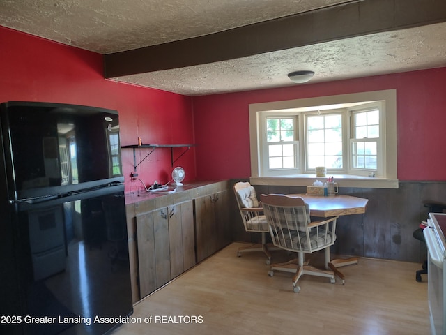 16711 Stark Rd, Springport, MI 49284 - kitchen featuring freestanding refrigerator, a textured ceiling, light wood-style flooring, and stove