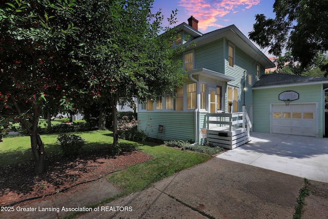 302 E State St, Saint Johns, MI 48879 - view of front facade with an attached garage, concrete driveway, a chimney, and a front lawn