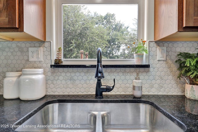 302 E State St, Saint Johns, MI 48879 - kitchen view of backsplash, dark countertops, and brown cabinets
