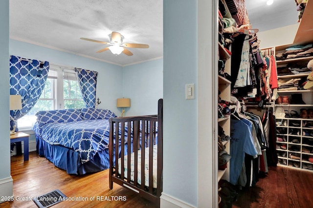 302 E State St, Saint Johns, MI 48879 - bedroom with wood finished floors, crown molding, and a ceiling fan
