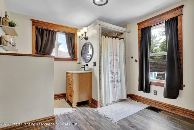 302 E State St, Saint Johns, MI 48879 - bathroom with vanity, wood finished floors, a shower with curtain, and a chandelier