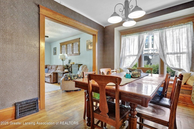 302 E State St, Saint Johns, MI 48879 - dining space featuring light wood-style floors, wallpapered walls, and a chandelier