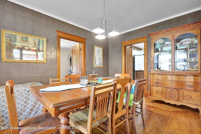 302 E State St, Saint Johns, MI 48879 - dining space with wallpapered walls, hardwood / wood-style floors, and a chandelier