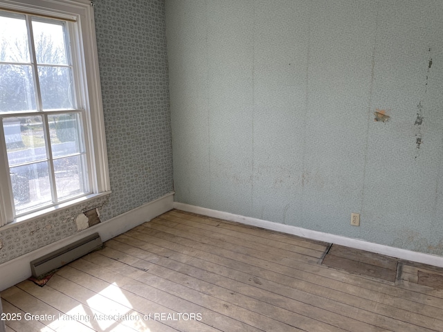 2111 Cedar St, Holt, MI 48842 - unfurnished room featuring baseboard heating, hardwood / wood-style flooring, and plenty of natural light