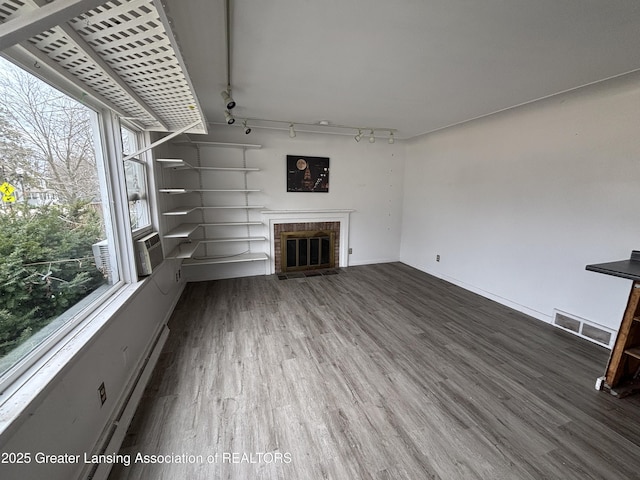 2111 Cedar St, Holt, MI 48842 - unfurnished living room with rail lighting, wood finished floors, and a fireplace