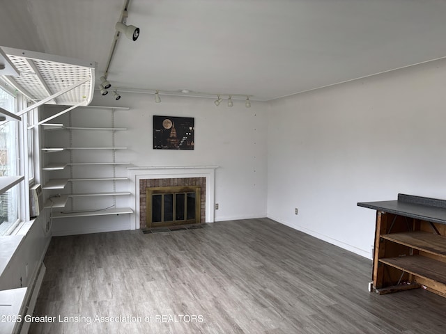 2111 Cedar St, Holt, MI 48842 - unfurnished living room featuring track lighting, wood finished floors, and a glass covered fireplace