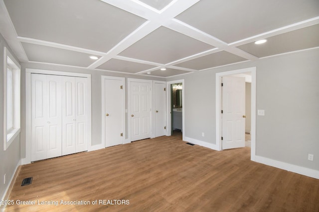 625 W Jefferson St, Grand Ledge, MI 48837 - unfurnished bedroom with coffered ceiling, recessed lighting, wood finished floors, multiple closets, and connected bathroom