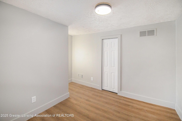 625 W Jefferson St, Grand Ledge, MI 48837 - unfurnished room featuring a textured ceiling and light wood-style flooring
