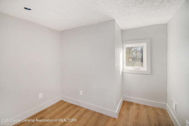 625 W Jefferson St, Grand Ledge, MI 48837 - spare room featuring light wood-type flooring and a textured ceiling