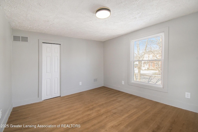 625 W Jefferson St, Grand Ledge, MI 48837 - spare room with wood finished floors and a textured ceiling