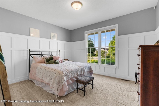 3537 Winborn Dr, Dewitt, MI 48820 - bedroom with a decorative wall, light carpet, and wainscoting