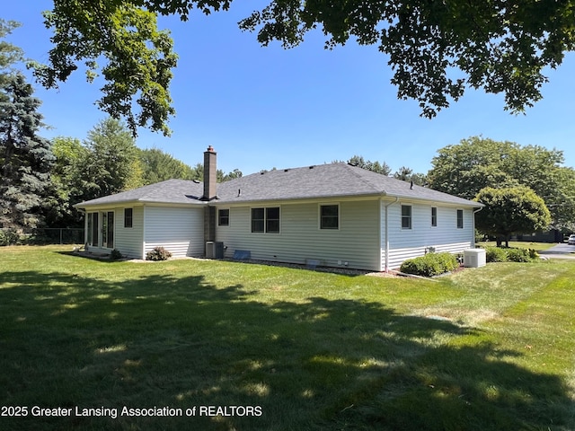 6716 Bunker Hill Dr, Lansing, MI 48906 - back of house featuring a yard and a chimney