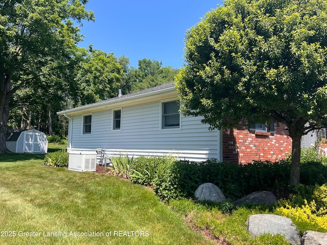 6716 Bunker Hill Dr, Lansing, MI 48906 - view of side of property featuring a storage shed and a lawn