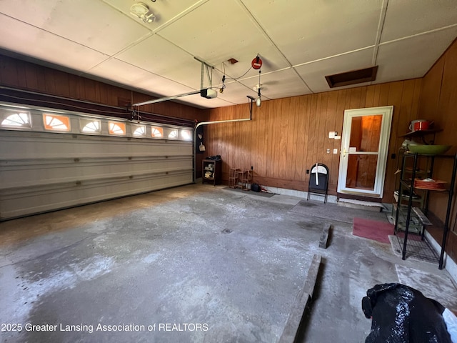 6716 Bunker Hill Dr, Lansing, MI 48906 - garage featuring a garage door opener and wood walls