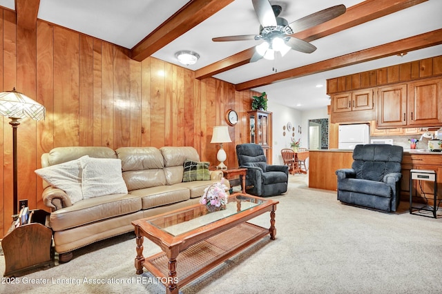 6716 Bunker Hill Dr, Lansing, MI 48906 - living area featuring light colored carpet, beamed ceiling, a ceiling fan, and wooden walls
