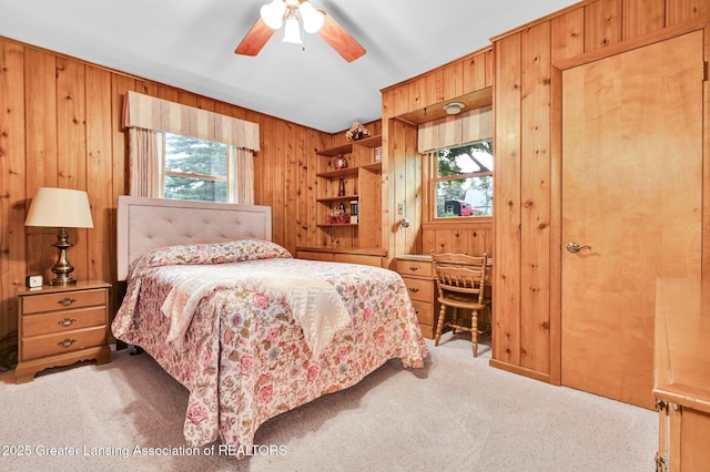 6716 Bunker Hill Dr, Lansing, MI 48906 - carpeted bedroom with wood walls and a ceiling fan