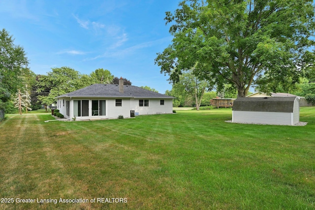 6716 Bunker Hill Dr, Lansing, MI 48906 - back of house featuring a storage unit, a lawn, and a chimney
