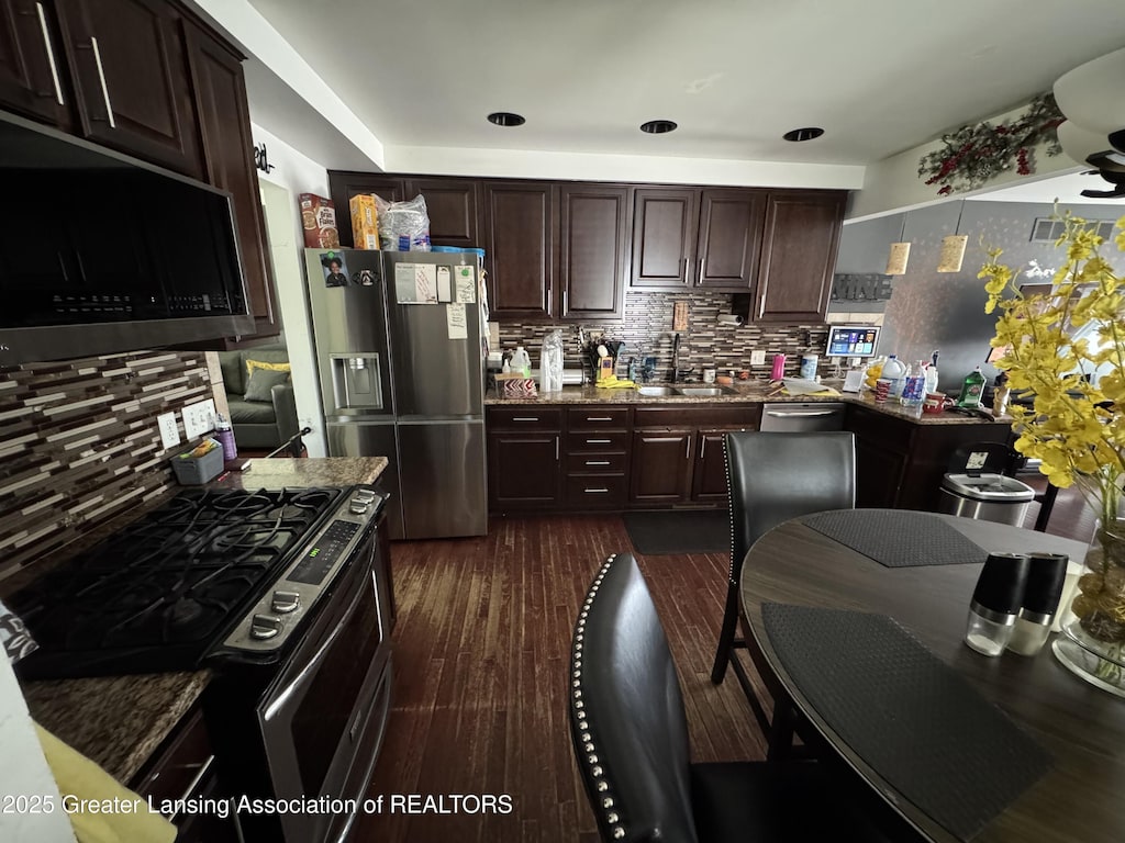 816 Arcola St, Garden City, MI 48135 - kitchen with appliances with stainless steel finishes, tasteful backsplash, dark brown cabinetry, and dark wood-style floors