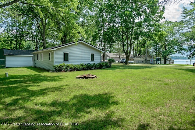 1337 Shepard St, Crystal, MI 48818 - view of green lawn featuring an outdoor fire pit and a water view