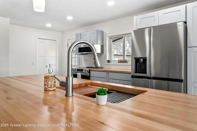 1337 Shepard St, Crystal, MI 48818 - kitchen with stainless steel appliances, butcher block counters, recessed lighting, and gray cabinetry