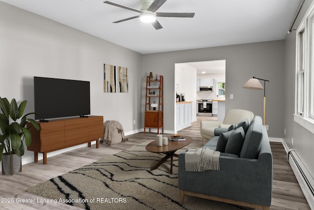 1337 Shepard St, Crystal, MI 48818 - living area featuring a baseboard heating unit, wood finished floors, and ceiling fan