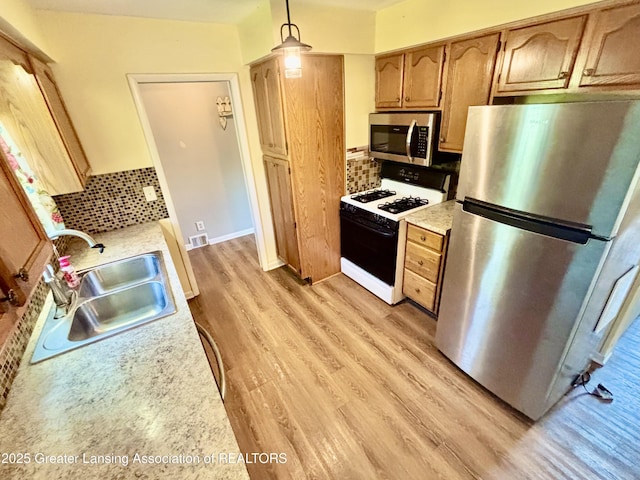 1214 Otto Rd Unit R1, Charlotte, MI 48813 - kitchen with stainless steel appliances, light wood-type flooring, light countertops, and tasteful backsplash