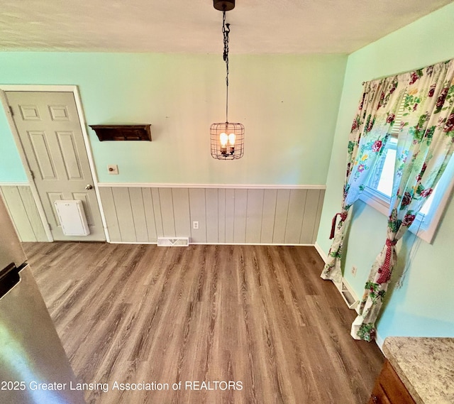 1214 Otto Rd Unit R1, Charlotte, MI 48813 - unfurnished dining area with wood finished floors and a wainscoted wall
