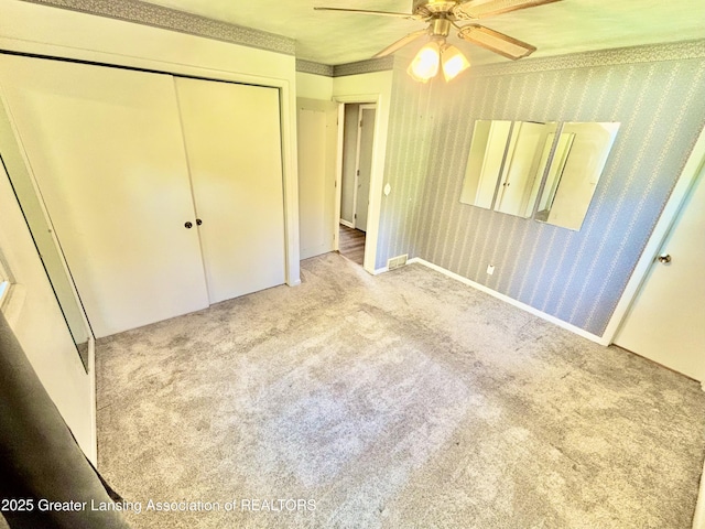 1214 Otto Rd Unit R1, Charlotte, MI 48813 - unfurnished bedroom featuring carpet flooring, a closet, ceiling fan, and wallpapered walls