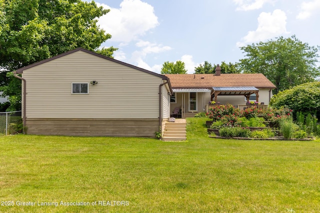 1220 Seymour St, Grand Ledge, MI 48837 - back of house featuring a chimney and roof with shingles