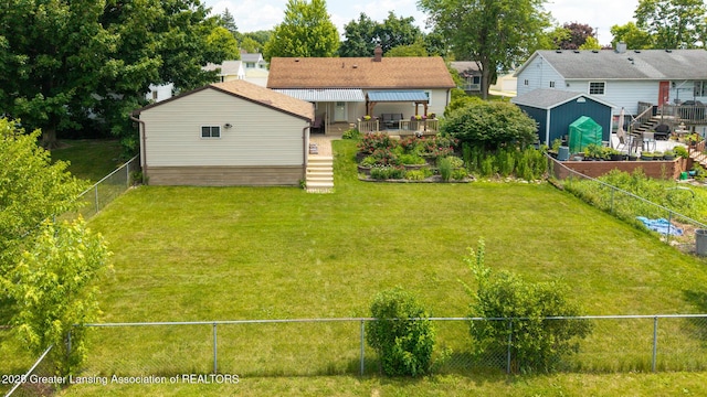 1220 Seymour St, Grand Ledge, MI 48837 - rear view of house with a fenced backyard, a shed, and a deck