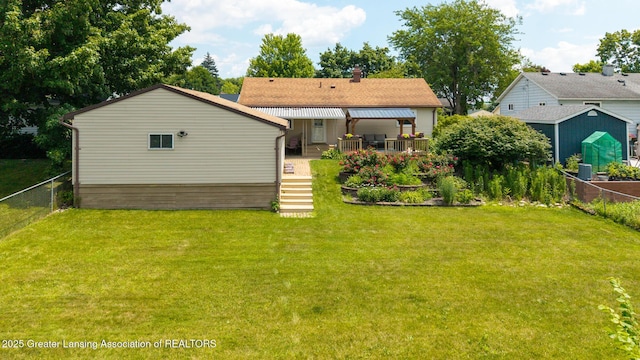 1220 Seymour St, Grand Ledge, MI 48837 - rear view of house with a fenced backyard, a chimney, a shed, and roof with shingles