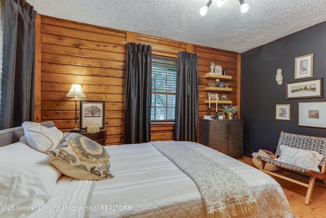 3536 N Royston Rd, Potterville, MI 48876 - bedroom featuring a textured ceiling, wood finished floors, and rustic walls