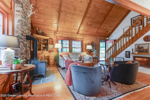 3536 N Royston Rd, Potterville, MI 48876 - living room with stairway, wood finished floors, high vaulted ceiling, a wood stove, and a wood ceiling with exposed beams