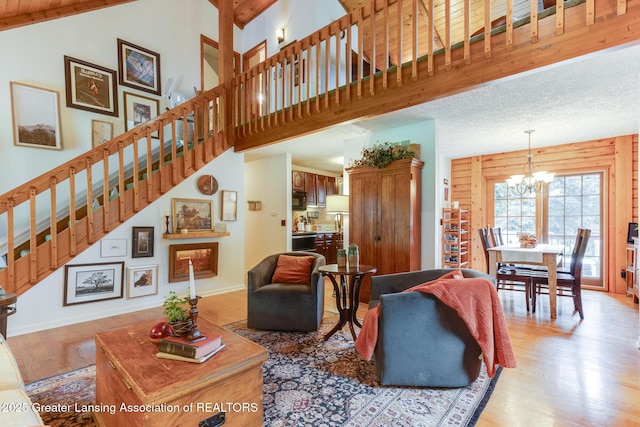3536 N Royston Rd, Potterville, MI 48876 - living room with wood finished floors, stairs, a chandelier, and a high ceiling