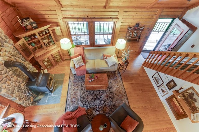3536 N Royston Rd, Potterville, MI 48876 - living area featuring a wood stove, plenty of natural light, wood finished floors, wooden ceiling, and wooden walls