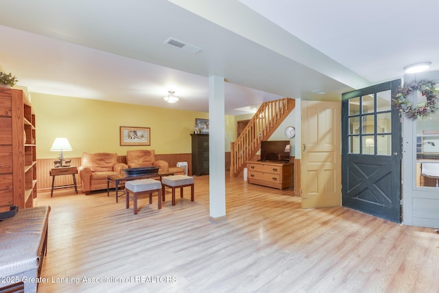 3536 N Royston Rd, Potterville, MI 48876 - living room with stairway, light wood-style floors, and a wainscoted wall