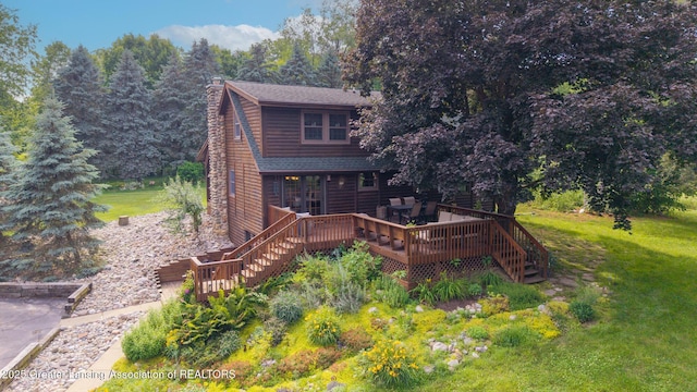 3536 N Royston Rd, Potterville, MI 48876 - rear view of house featuring a wooden deck, a chimney, stairway, a shingled roof, and a lawn