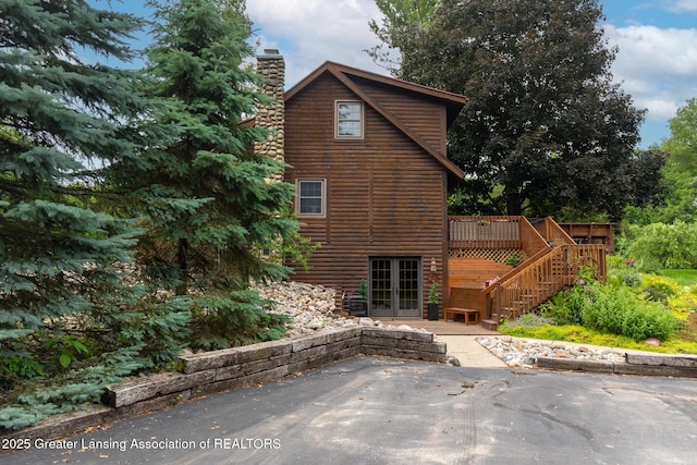 3536 N Royston Rd, Potterville, MI 48876 - view of side of home with french doors, a deck, a patio, a chimney, and stairs