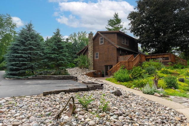 3536 N Royston Rd, Potterville, MI 48876 - view of home's exterior with stairs, a deck, and a chimney