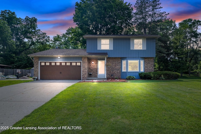4629 Grandwoods Dr, Lansing, MI 48917 - view of front of home with brick siding, an attached garage, and concrete driveway