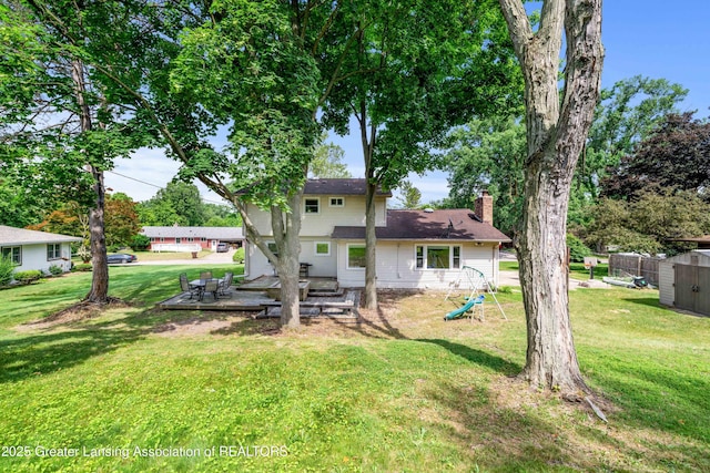 4629 Grandwoods Dr, Lansing, MI 48917 - back of property with a yard, a chimney, and a storage shed